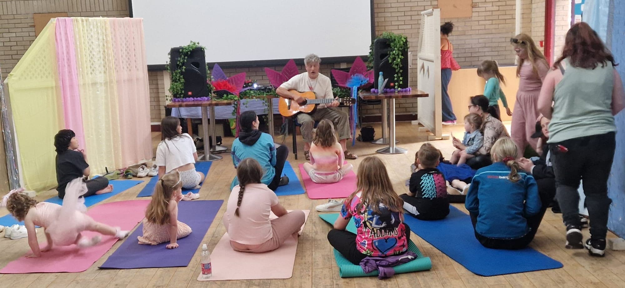 Families gathered around a guitar for a sing-along at the Funky Family Disco.